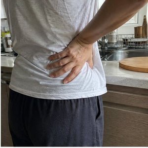Hand on a sore lower back